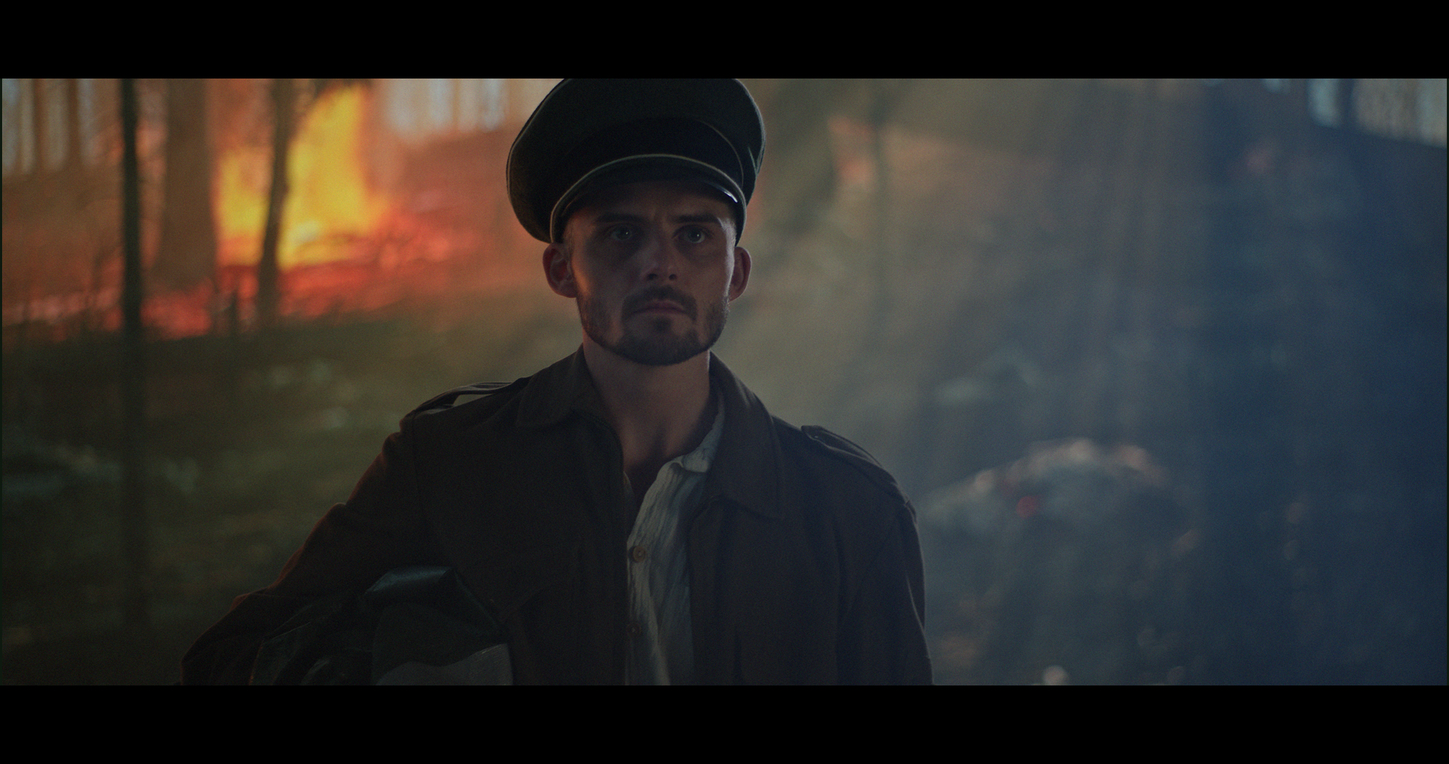 Liam Graham as a soldier in a period drama — military uniform, fire in the background
